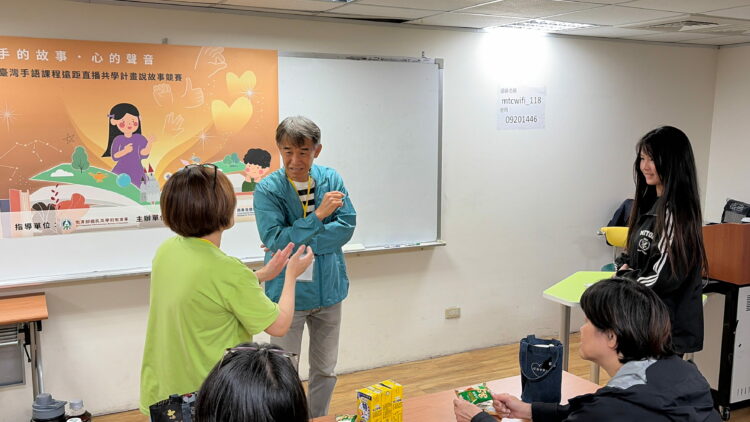 圖說:遠距團隊聾人老師洪文廣現身競賽會場，給學生加油打氣(圖/商研院)